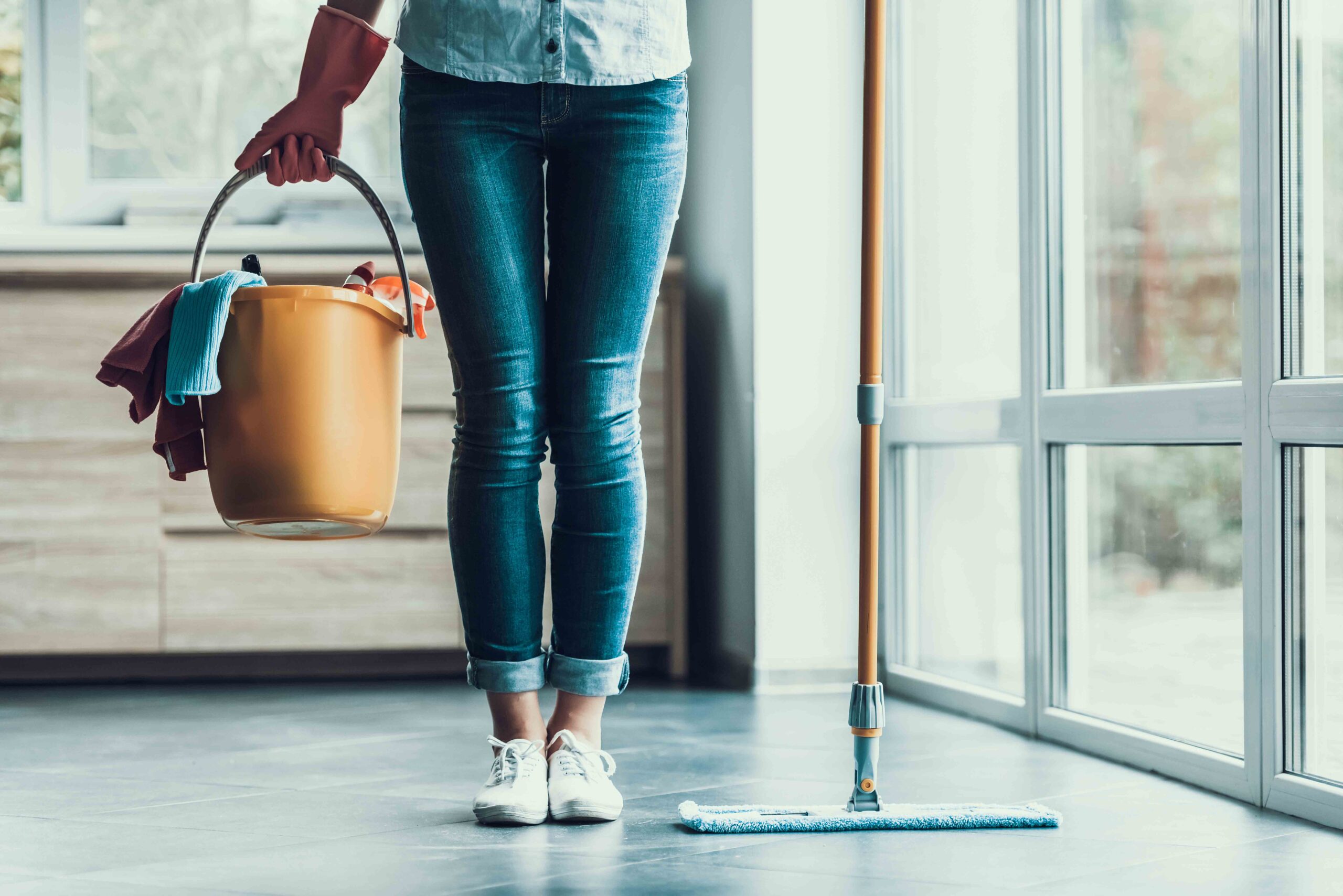 Young Woman holds cleaning bucket and mop